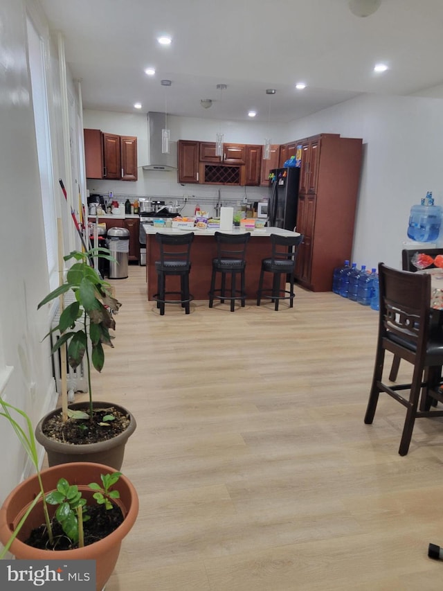 kitchen featuring a breakfast bar, light countertops, decorative light fixtures, and a center island