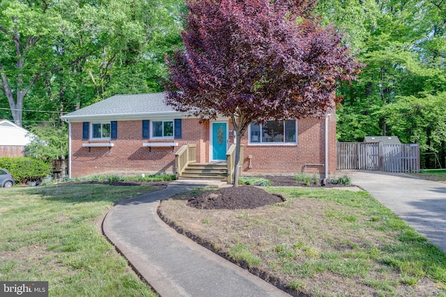 7424 Nancemond St, Springfield, VA 22150 - view of front facade with fence, driveway, brick siding, and a front yard