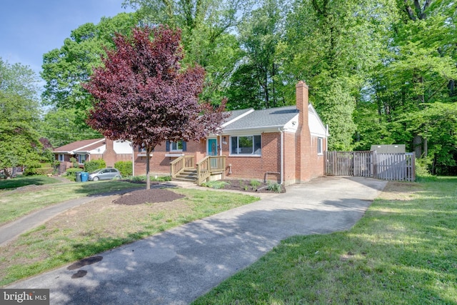7424 Nancemond St, Springfield, VA 22150 - view of front of house featuring a front lawn, brick siding, a gate, a chimney, and driveway