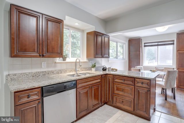 7424 Nancemond St, Springfield, VA 22150 - kitchen with stainless steel dishwasher, a sink, a peninsula, and light stone counters