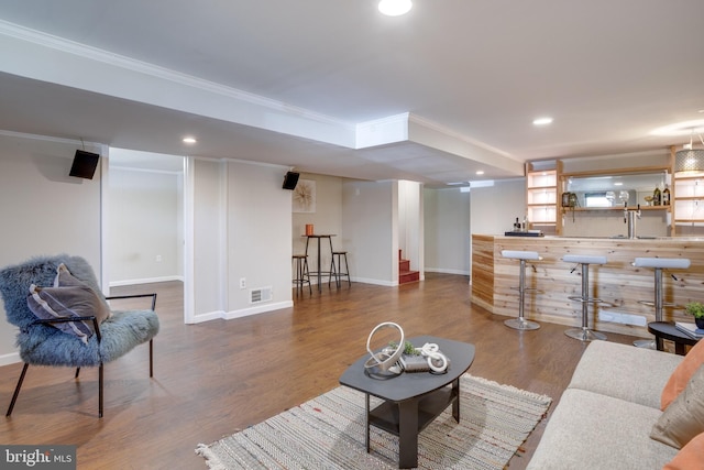 7424 Nancemond St, Springfield, VA 22150 - living room featuring crown molding, bar, baseboards, wood finished floors, and visible vents