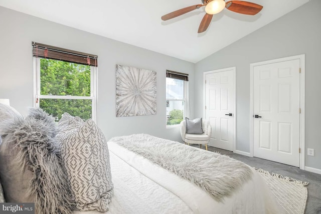 bedroom featuring multiple windows, vaulted ceiling, carpet floors, baseboards, and ceiling fan