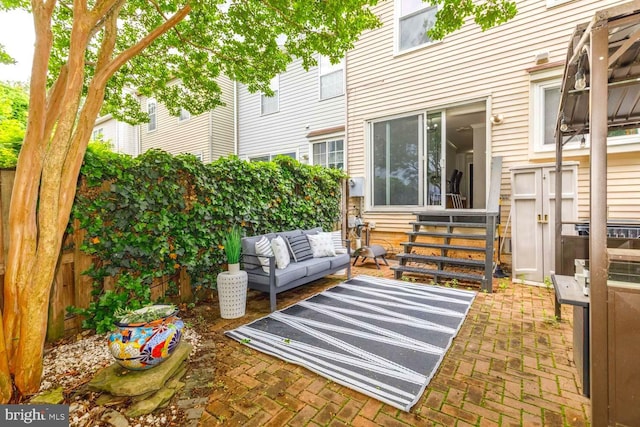 view of patio featuring entry steps, an outdoor hangout area, and fence