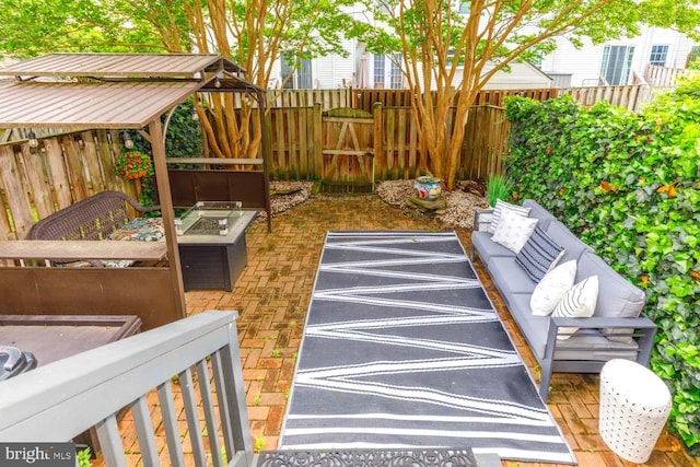view of patio with a fenced backyard and an outdoor living space with a fire pit