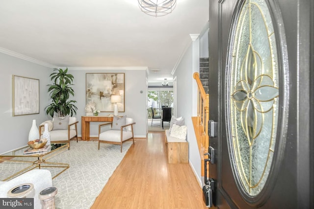 foyer featuring wood finished floors, crown molding, stairway, and baseboards