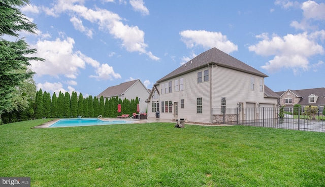 back of house with a fenced in pool, an attached garage, fence, a yard, and a patio area