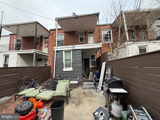 back of property featuring brick siding and fence