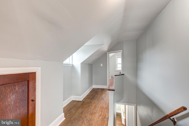 additional living space featuring baseboards, vaulted ceiling, and wood finished floors