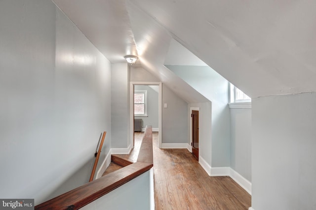 bonus room with lofted ceiling, radiator, baseboards, and wood finished floors