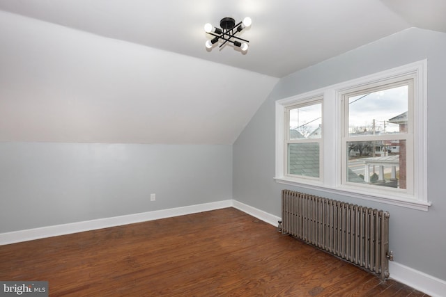 additional living space featuring radiator, baseboards, vaulted ceiling, and dark wood-style flooring