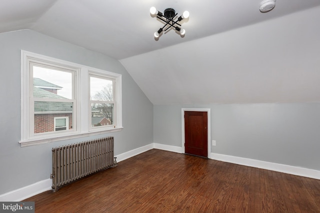 bonus room featuring radiator heating unit, baseboards, and dark wood-type flooring