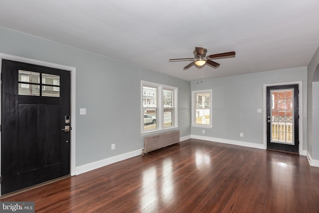 foyer with radiator, ceiling fan, baseboards, and dark wood-type flooring