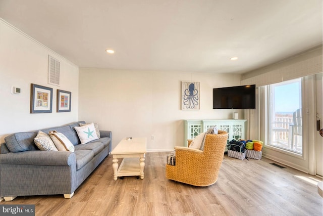 living area with light wood finished floors, baseboards, visible vents, and recessed lighting