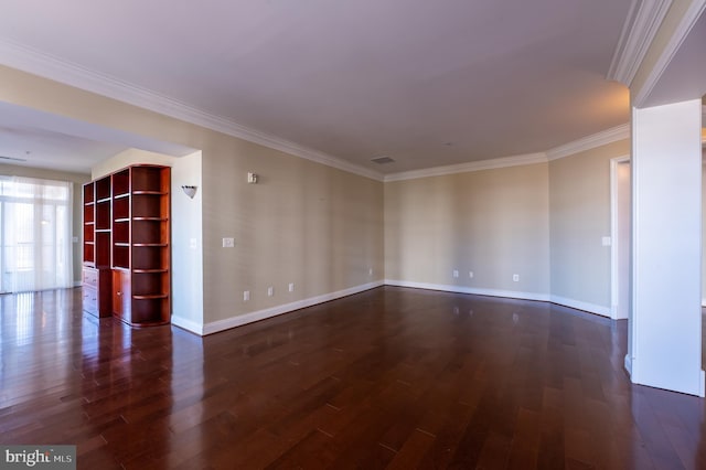 spare room featuring ornamental molding, baseboards, and dark wood-style floors
