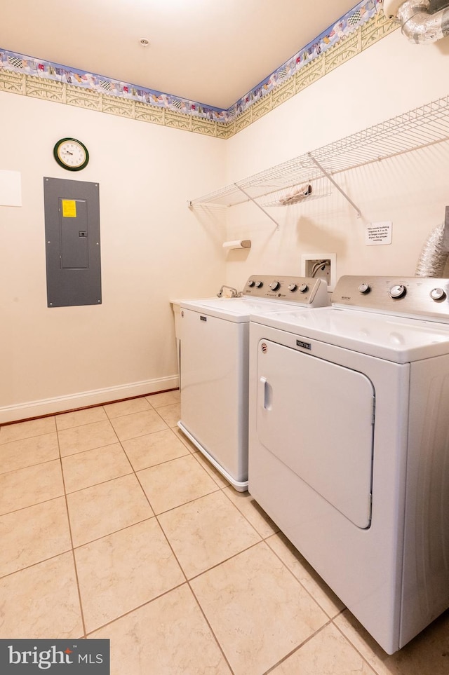 laundry area featuring laundry area, light tile patterned floors, electric panel, baseboards, and washing machine and dryer