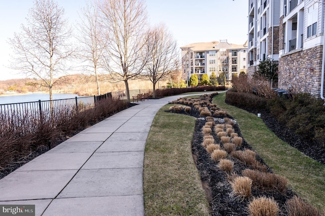 view of home's community with fence and a water view