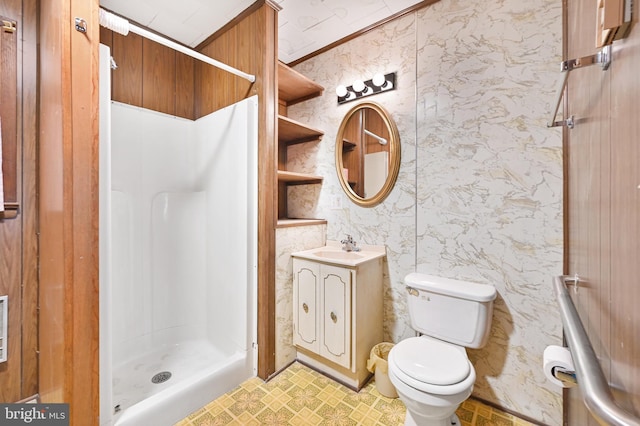 bathroom featuring toilet, vanity, wallpapered walls, a stall shower, and crown molding