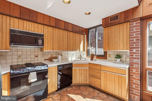 kitchen with visible vents, black appliances, a sink, backsplash, and light countertops