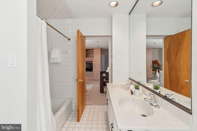 full bath with a sink, shower / tub combo, recessed lighting, and double vanity