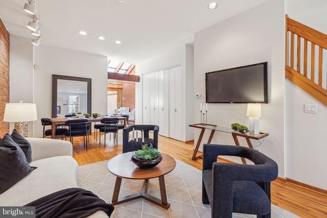 living area with recessed lighting, rail lighting, stairs, and light wood-type flooring