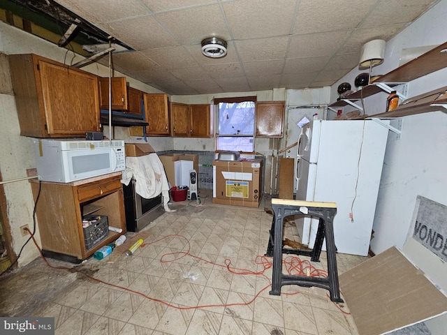 kitchen with white appliances, brown cabinets, a drop ceiling, and light floors