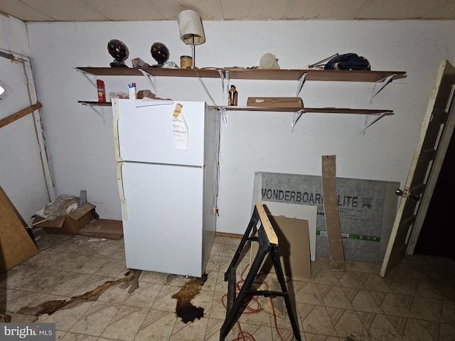 kitchen with open shelves, light floors, and freestanding refrigerator