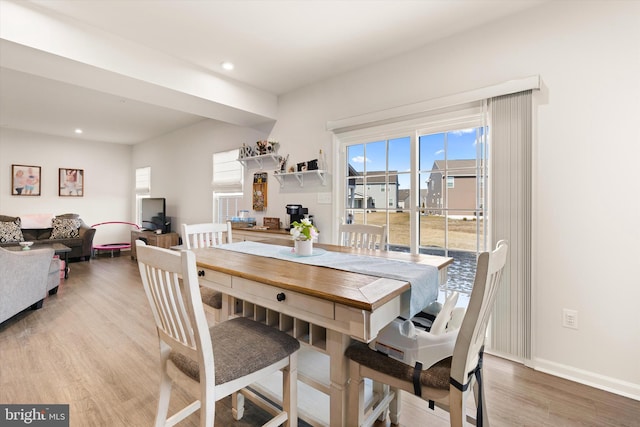 dining room with baseboards, wood finished floors, and recessed lighting