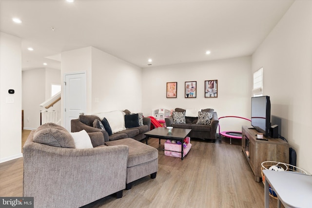 living area with light wood-type flooring, stairway, baseboards, and recessed lighting