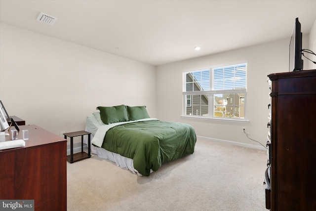 bedroom featuring light colored carpet, visible vents, and baseboards