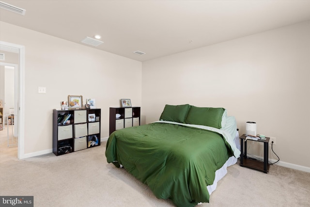 bedroom with baseboards, visible vents, and light colored carpet