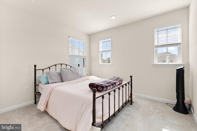 bedroom featuring light carpet and baseboards