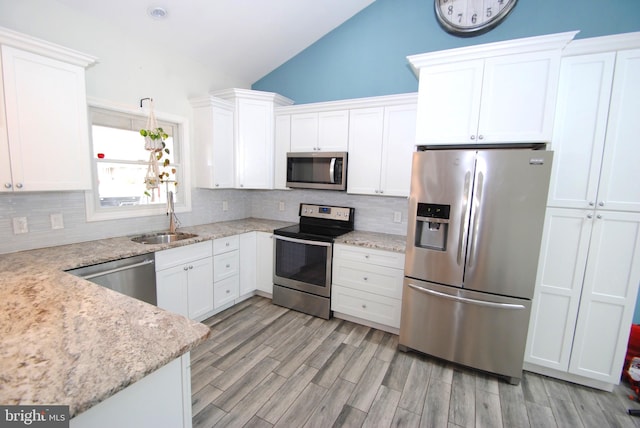 307 Broad St, Hainesport, NJ 08036 - kitchen featuring a sink, lofted ceiling, stainless steel appliances, white cabinets, and decorative backsplash