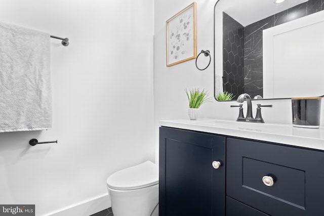 bathroom with vanity, toilet, and baseboards