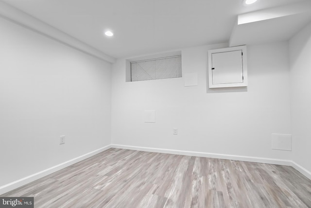 spare room featuring light wood finished floors, baseboards, and recessed lighting