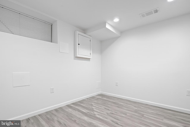 empty room with visible vents, light wood finished floors, and baseboards