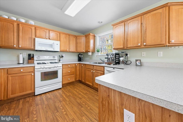 kitchen with brown cabinetry, white appliances, light countertops, and dark wood finished floors