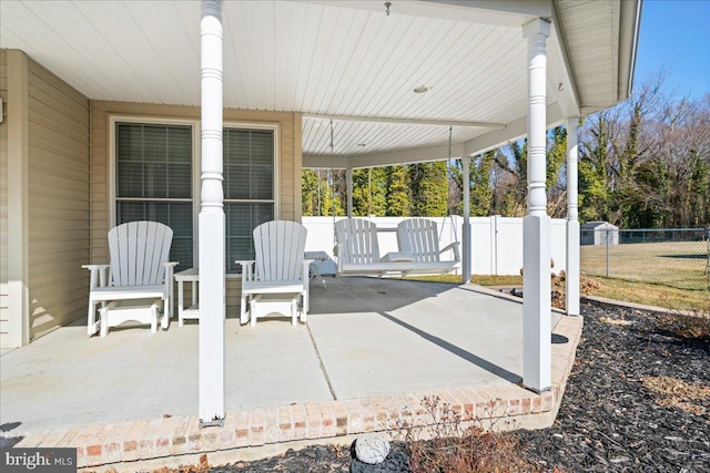 view of patio / terrace featuring an attached carport and fence