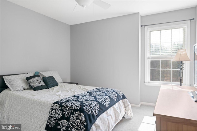 bedroom featuring baseboards, ceiling fan, and light colored carpet