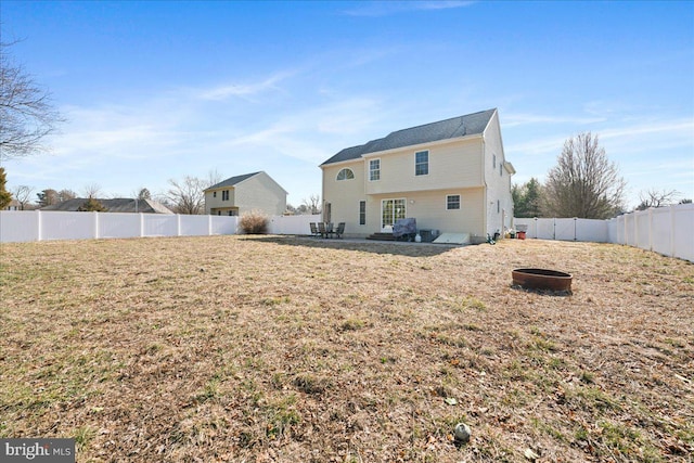 rear view of house featuring a fenced backyard and a lawn