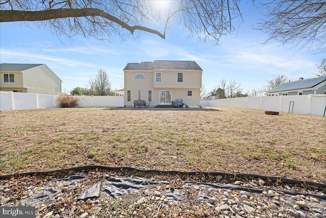 back of property featuring a yard and a fenced backyard