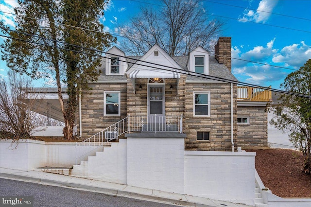 view of front of property with stone siding and a chimney