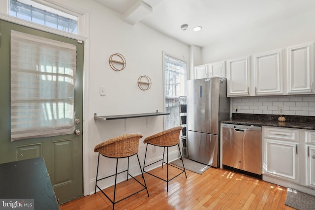 kitchen featuring stainless steel appliances, white cabinets, decorative backsplash, open shelves, and light wood finished floors