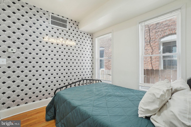 bedroom featuring wood finished floors, visible vents, and baseboards