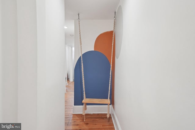 staircase featuring baseboards and wood finished floors