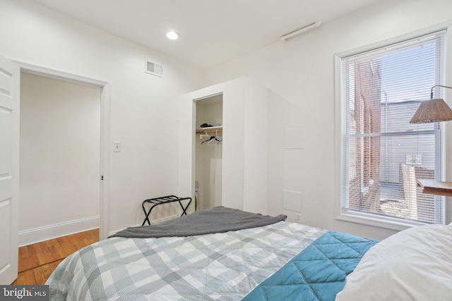 bedroom featuring multiple windows, visible vents, wood finished floors, and recessed lighting