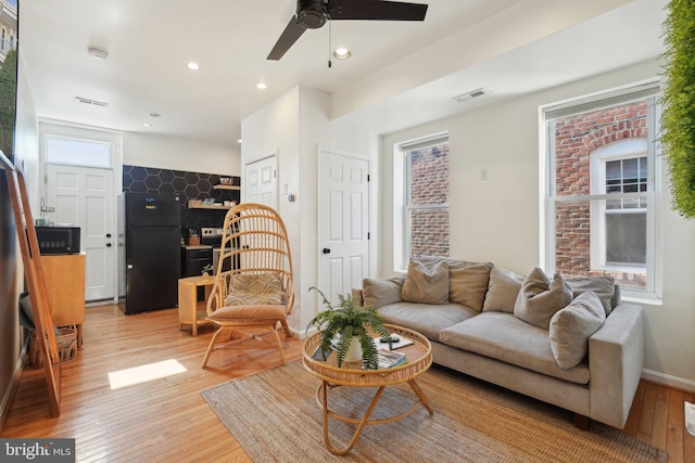 living area featuring light wood finished floors, recessed lighting, visible vents, a ceiling fan, and baseboards