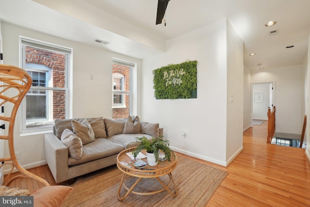 living room with visible vents, baseboards, light wood-style flooring, ceiling fan, and recessed lighting