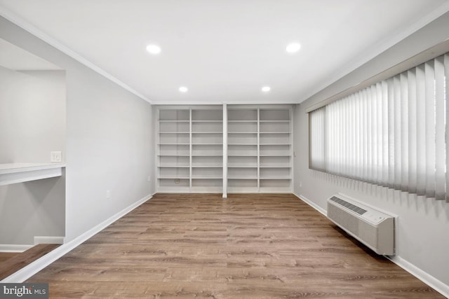 interior space with recessed lighting, an AC wall unit, baseboards, and wood finished floors