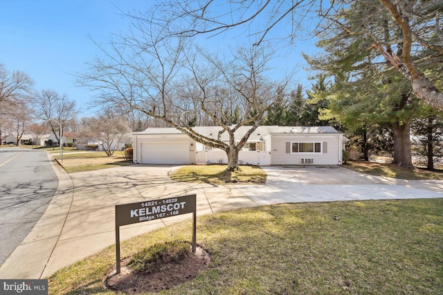 view of front of property with concrete driveway, a garage, and a front yard