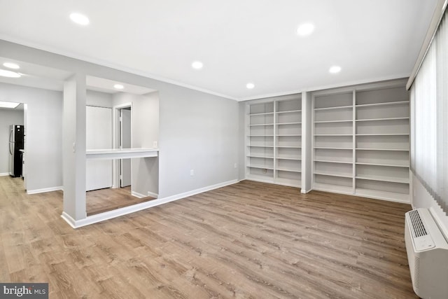 interior space featuring crown molding, baseboards, recessed lighting, freestanding refrigerator, and wood finished floors